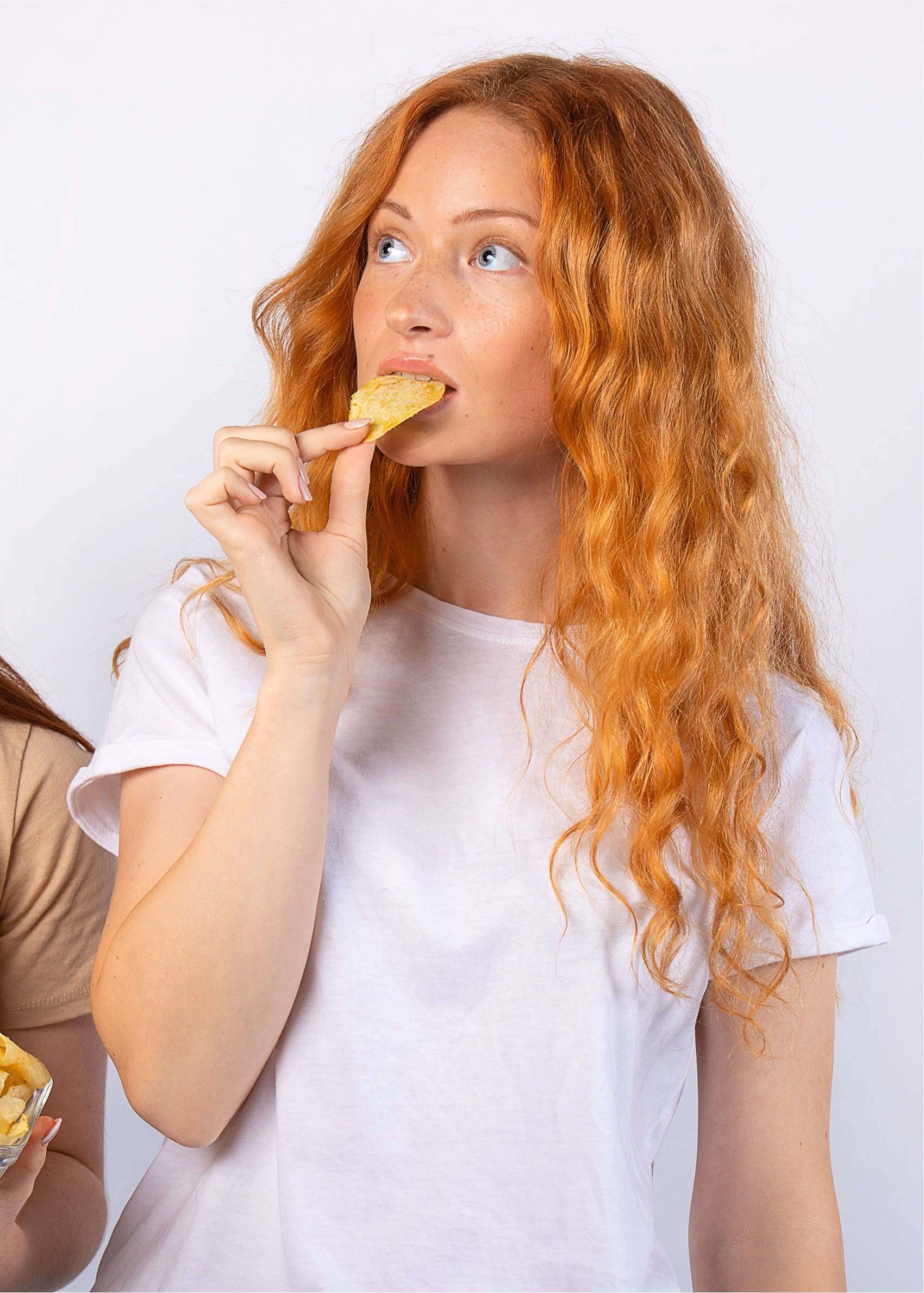 Woman enjoying a IRON SNACK beef jerkey in a clean studio setting.